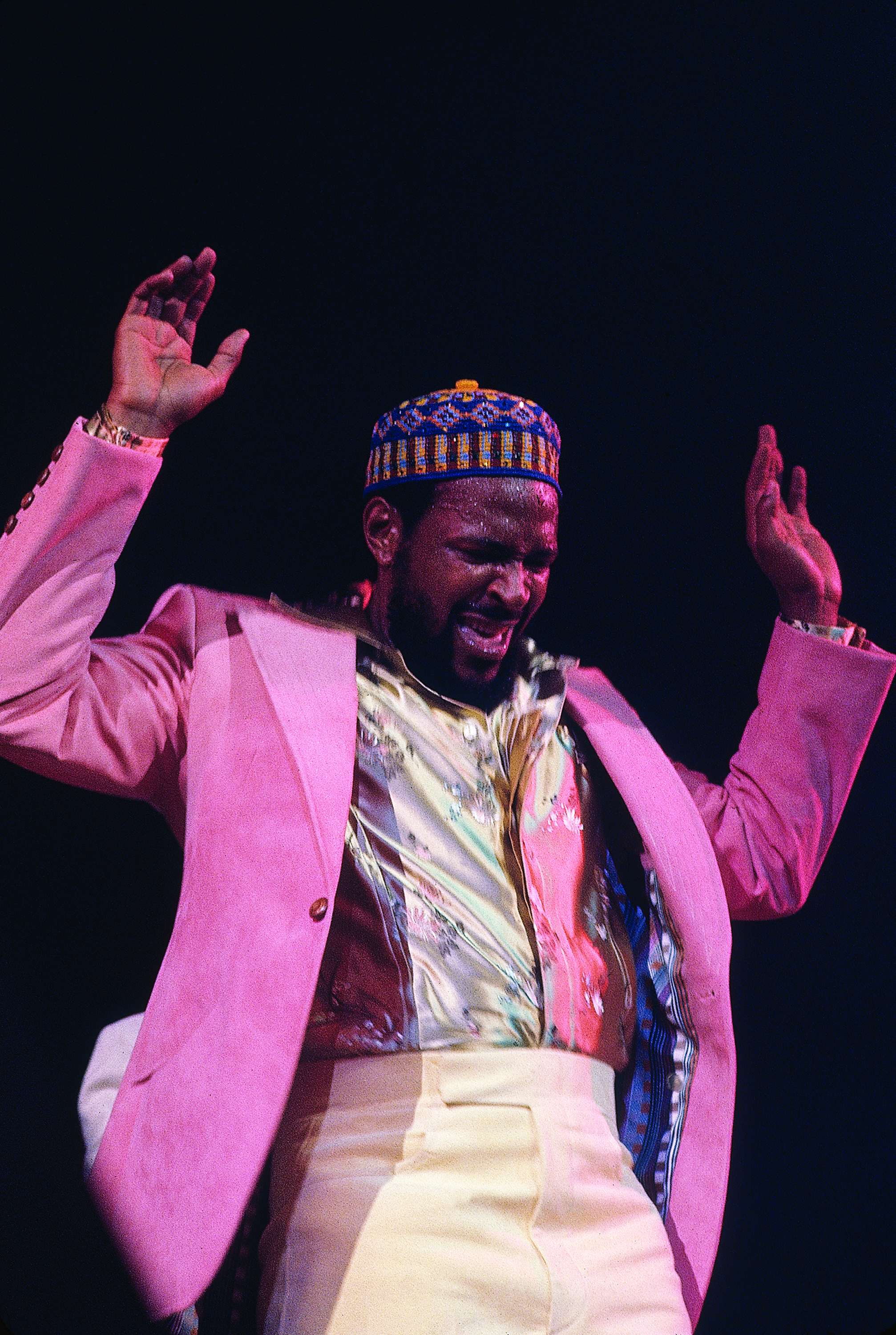 Man raises his arms while appearing to sing