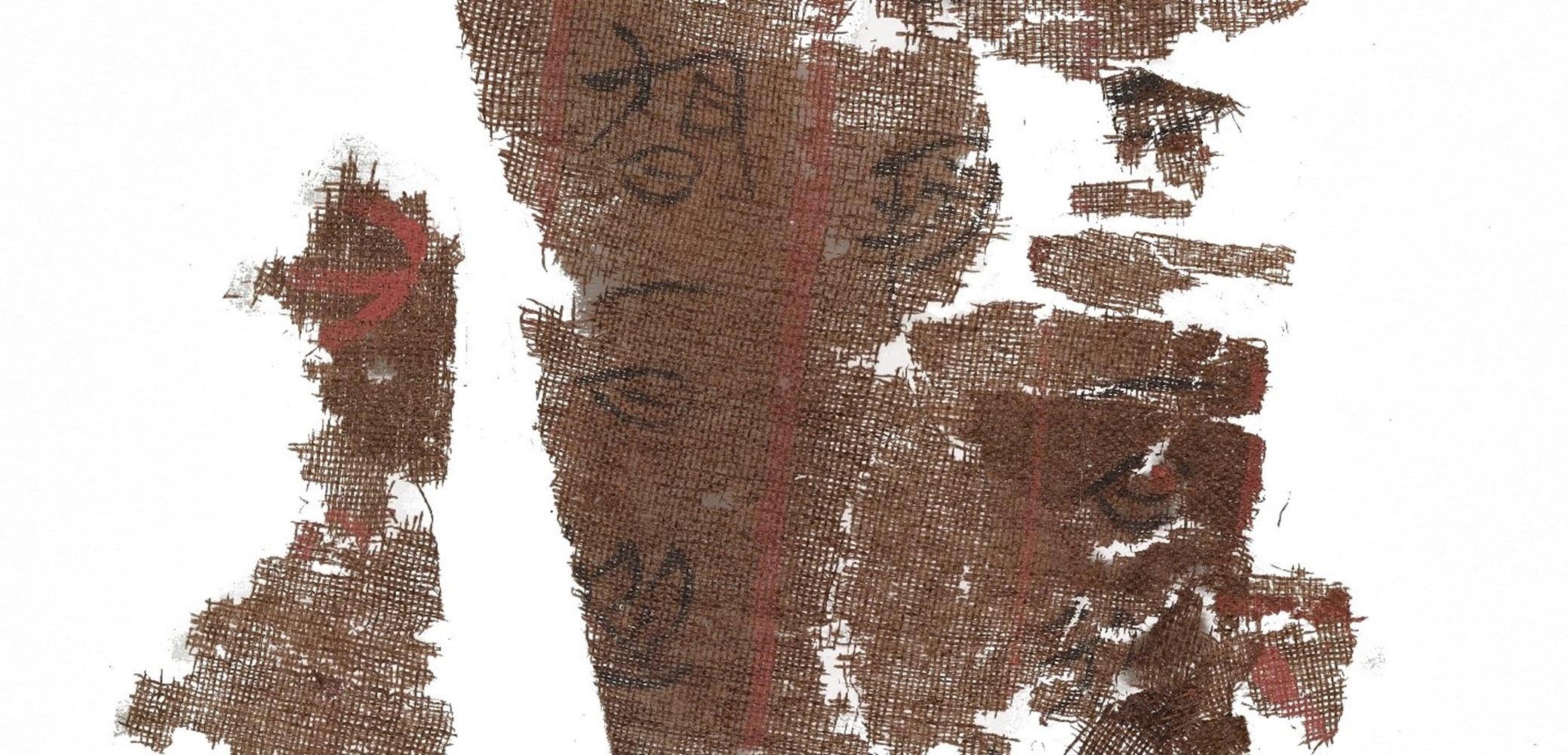 Torn pieces of brown cloth with faded black calligraphy.