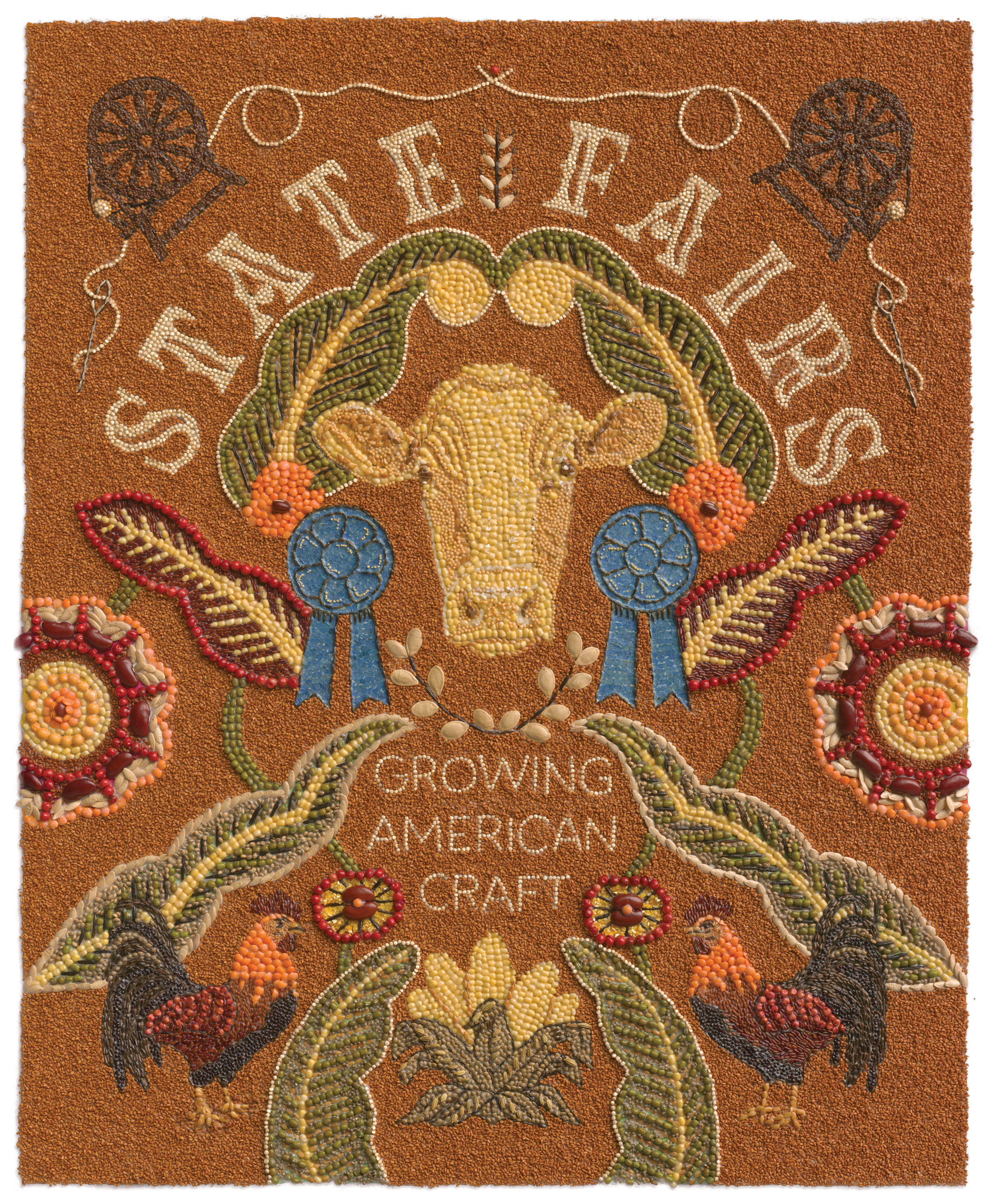Textile in warm colors with floral designs, a cows face and lettering.