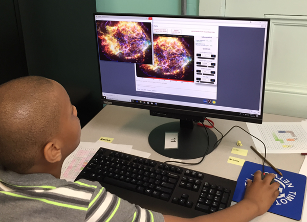 Child looks at a computer monitor