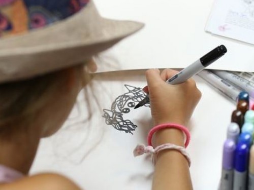 Girl drawing with a pen.