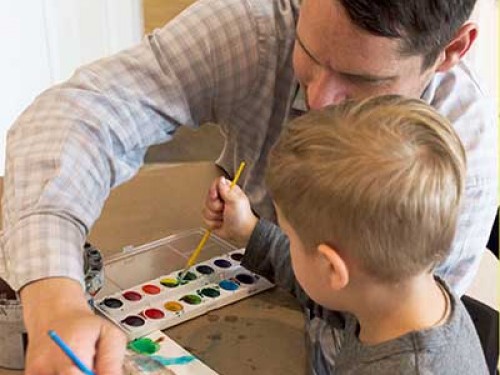 Parent painting with a child.