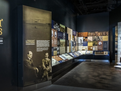 Entrance to Wright Brothers exhibit at museum. Views of old planes and photographs in the background
