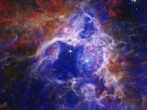 Image of outer space with stars and clouds of blue and purple.