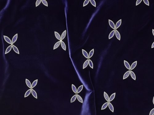 Close-up of blue velvet gown with beaded x shapes.