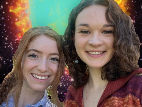 Two women stand next to each other smiling, with a graphic projection of a colorful blue and orange circular star in background.