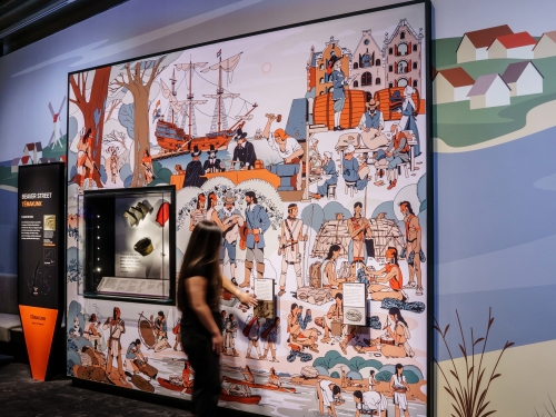 Person interacts with museum exhibit wall