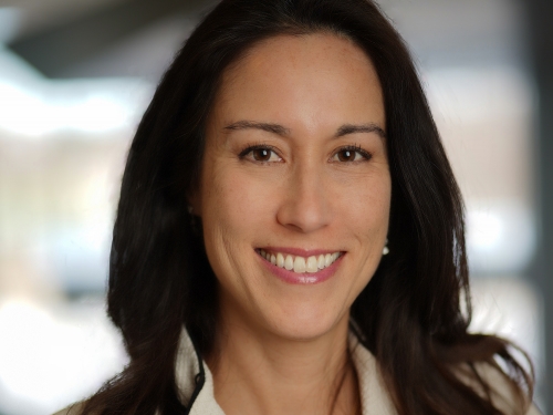 Headshot of a woman with brown, shoulder-length hair smiling..