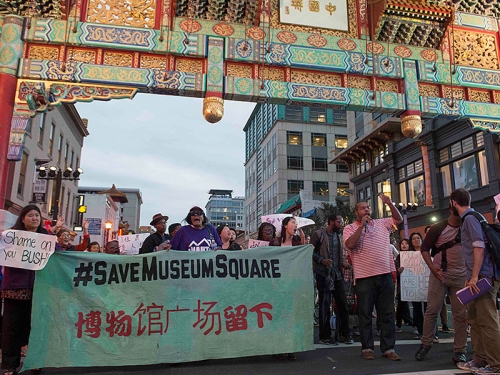 Crowd holding protest signs in Chinatown