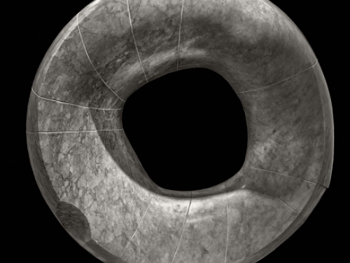 Sculpture of circular stone disc with hole in the middle