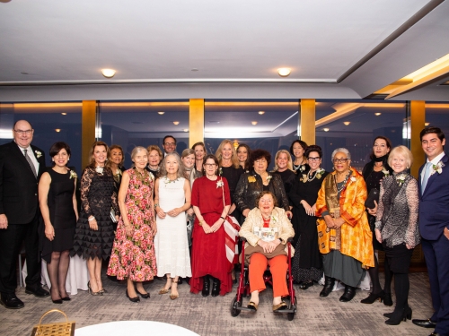 Group photo of over a dozen people in cocktail attire