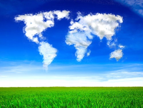 Grass field with clouds in the form of a world map