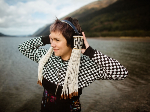 Woman wearing headphones with tribal decorations