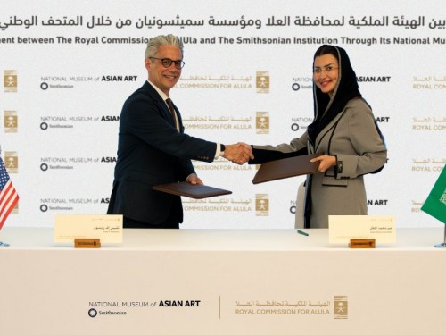 A man and a woman shake hands after signing an agreement,