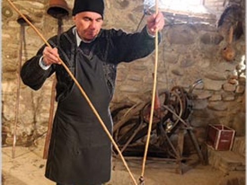 Man in ethnic dress demonstrating traditional wine-making