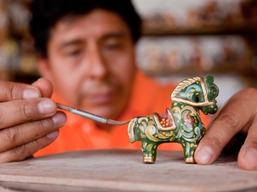 Artists painting a small horse figurine