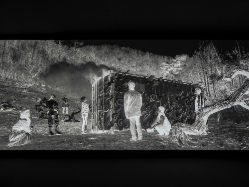 Black and white negative still image of people standing randomly in group