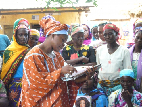 Woman stands and reads as a crowd of women watch
