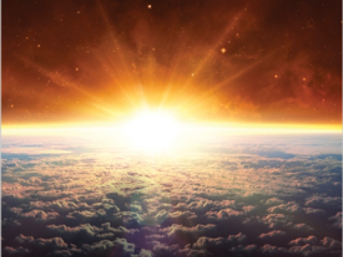 Sun rising over clouds
