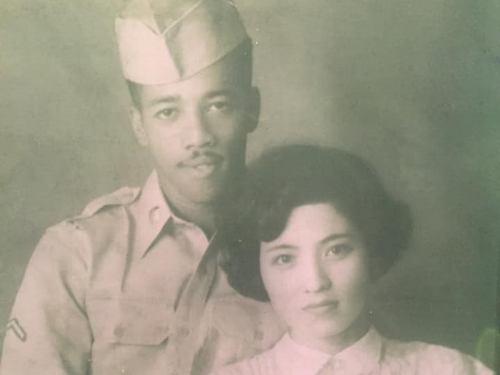 Vintage photo of a young couple with a man in military uniform and woman in white outfit.