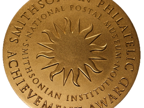 Gold medallion with etched sunburst in center and words around the edge.