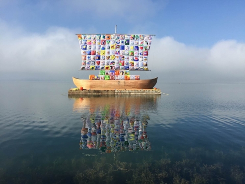 model of wooden ship with colorful sail