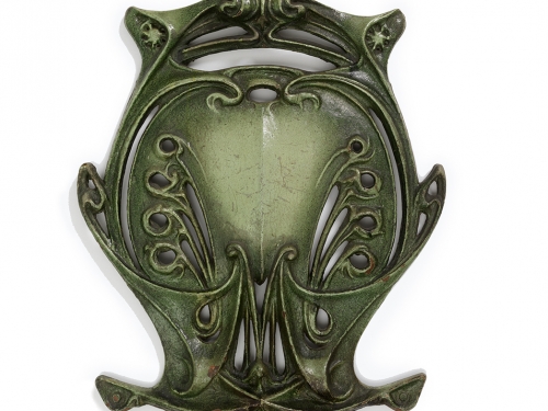 Green decorative art piece in nouveau style next to print pamphlet in a graphic style
