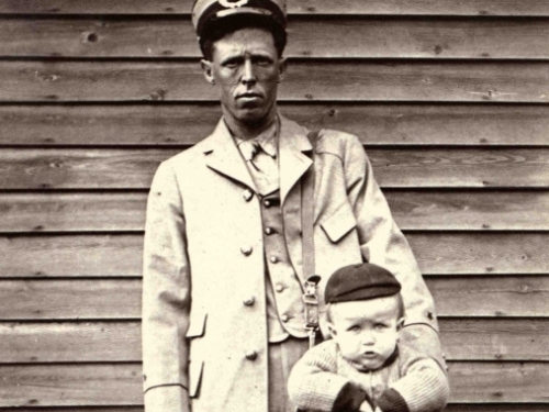 Photo of mail carrier with baby in a mailbag