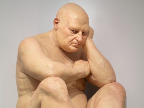 Big Man sculpture (overweight bald man sitting with head on hand)