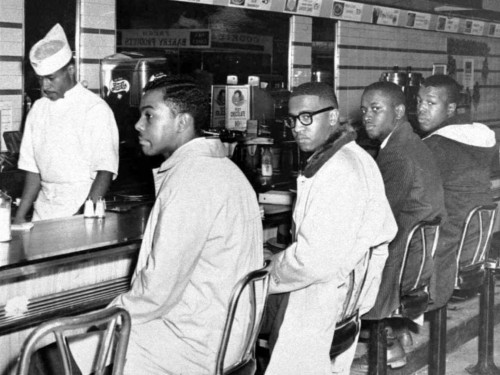 four young men sitting at a lunch counter