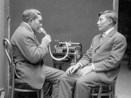 indigenous men speak with vintage recorder