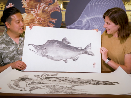 Artist Dwight Hwang shows off an artwork of a fish.
