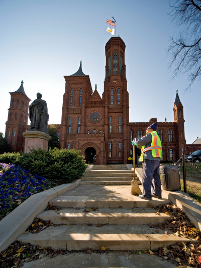 Person standing on the steps looking at statue holding a broom
