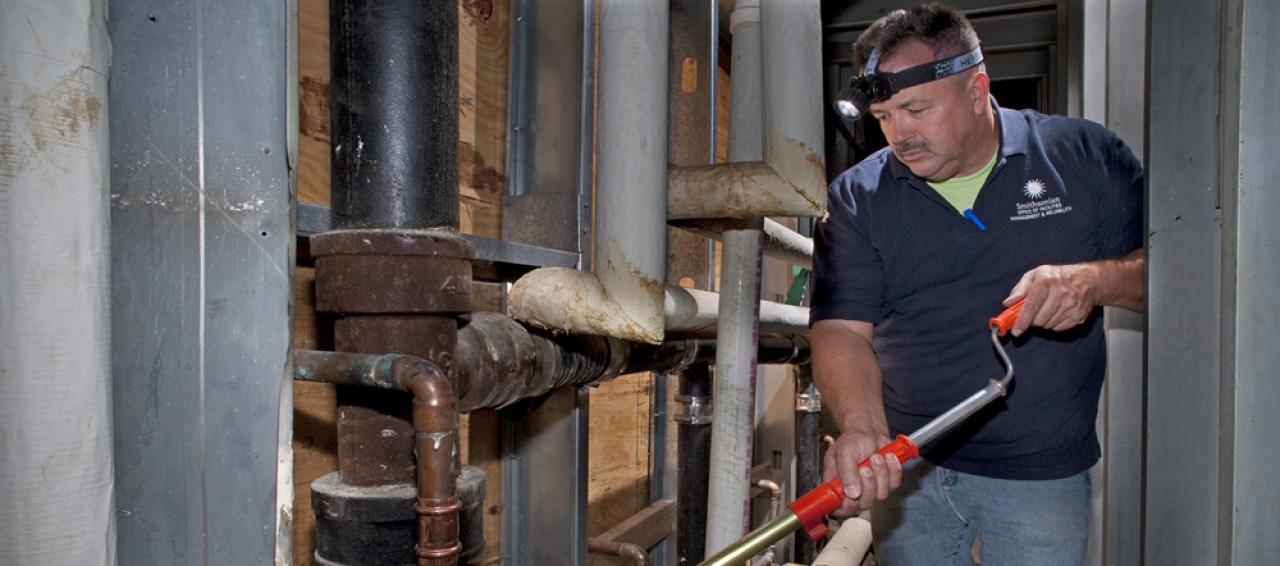 Image of a man with a device in his hand performing an equipment inspection