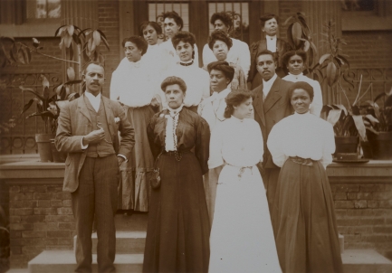 Group of teachers stand outside of a school