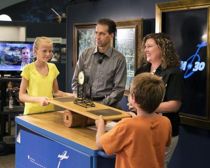Children posing with pendulum model