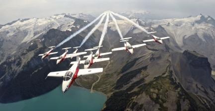 Canadian military planes in formation over mountains