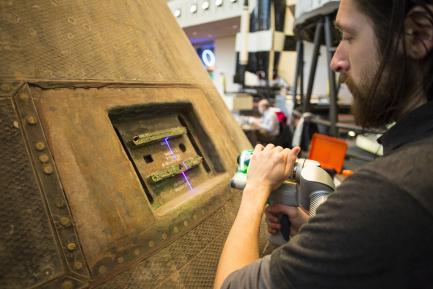 technician scans command module in close-up view