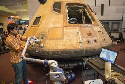 technician using laser to scan command module