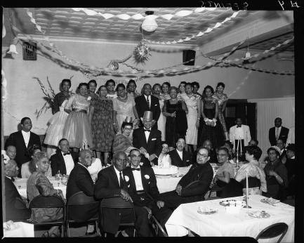 Group photo taken among tables with white tablecloths