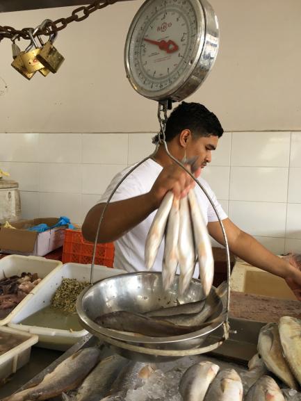 A fishmonger weighing fish