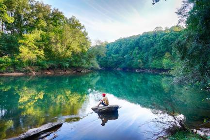 A fisherman on a placid lake