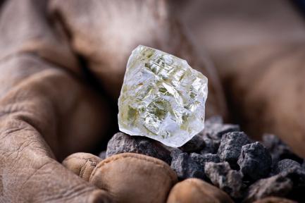 Uncut diamond held in dirty hand