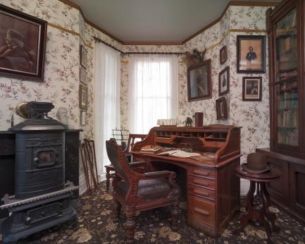 Room with desk and cast iron stovr