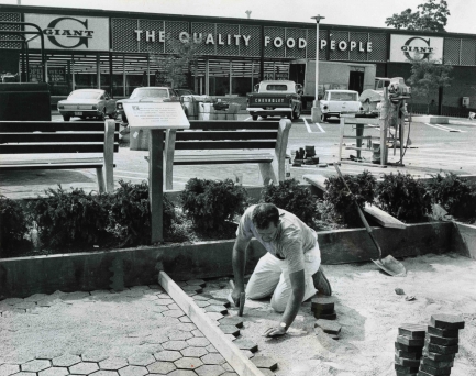 Man repairing road in front of supermarket