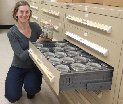 Researcher Hannah Wood holds jar with specimens
