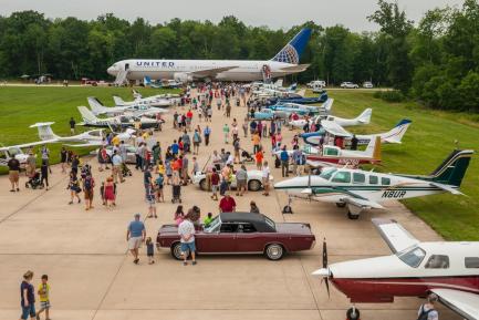 Visitors with aircraft and vehicles parked along runway