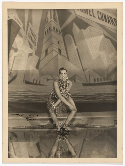 Woman dancing on stage bends over with hands on opposite knees.