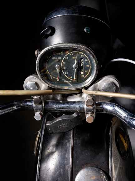Close-up image of circular dial with numbers indicating speed on a motorcycle.