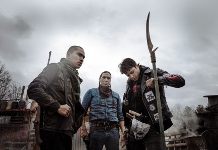 Three armed Native men, one staring into camera